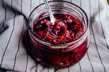 Koyu arkaplandaki bir kavanozdaki gül yapraklarından ev yapımı reçel