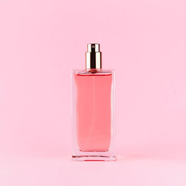 Açık pembe arka planda parfüm şişesi