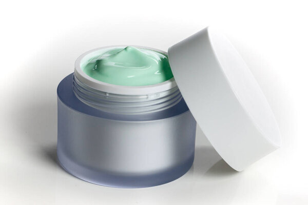 Стеклянная банка крема для лица с кепкой. Изолированный на белом фоне
