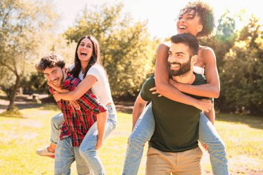 Kırsalda eğlenen bir grup melez genç sırt üstü dövüşüyorlar. Yaşam tarzı Pazar veya tatil konsepti.