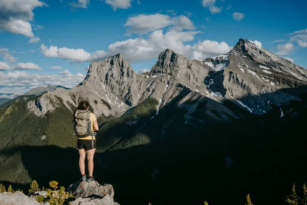 Kanadanın Alberta şehrindeki Grassi Knob dağının zirvesinden Canmore 'un yukarısındaki ikonik üç kız kardeşin güzel dağ manzarasına bakan yürüyüşçü kadın.