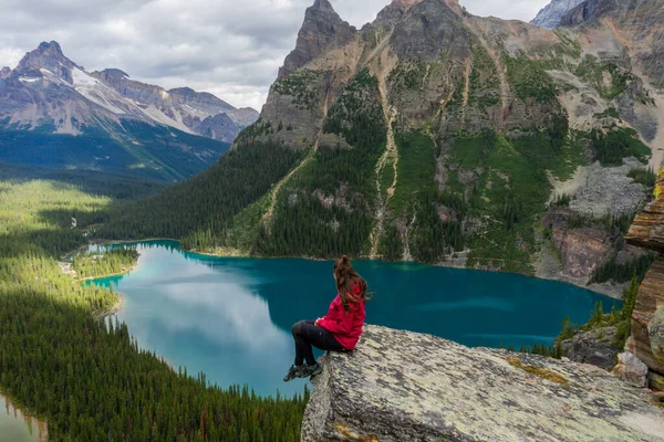 Opabin Prospect 'in tepesinde, O' Hara Gölü ve Mary Gölü 'ne bakan ve arkasında Kanada Kayalıkları olan gezgin kadın. British Columbia, Kanada