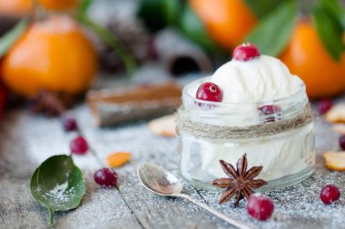 Yeni yıl ve Noel atmosferi: tatlı tatil tatlı baharatlar ve koyu ahşap arka plan üzerinde cranberries ile dondurma.