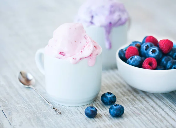 白いカップと新鮮な果実のアイスクリームをベリー ラズベリーとブルーベリー軽い木製の背景に — ストック写真