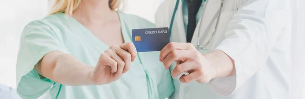 A beautiful girl patient and a young doctor happily carrying a credit card in their hand. Credit card and medical payment for hospital patients. Good health and credit cards for hospital patients.