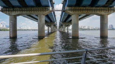 Köprünün altından geniş nehrin manzarası Seul şehrinde destek görüyor.