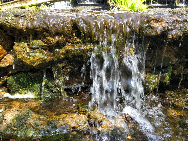 Mini cascata sulle rocce in una giornata di sole — Foto Stock