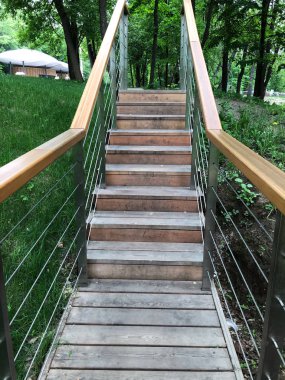 yeşil arka planda açık gri ahşap merdiven