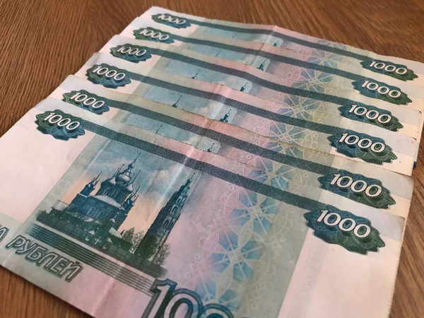 Ahşap bir arka plan üzerinde 1000 ruble mezheplerde Rus banknotlar