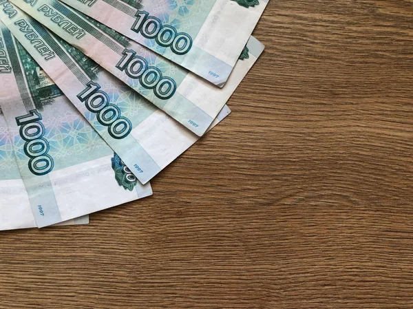 Російські банкноти номіналом в 1000 рублів на дерев'яному фоні — стокове фото