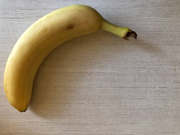 Банан на світлому фоні з простором для тексту — стокове фото