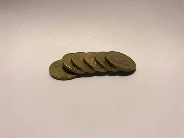 Ocelové zlaté mince na bílém pozadí — Stock fotografie
