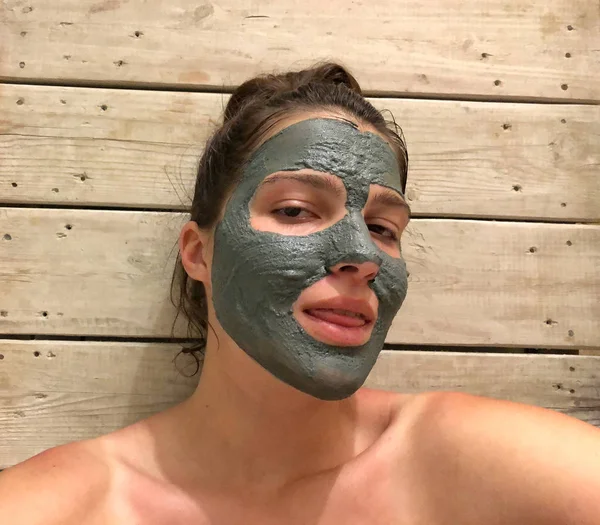 Belle femme avec une argile ou un masque de boue sur le visage — Photo