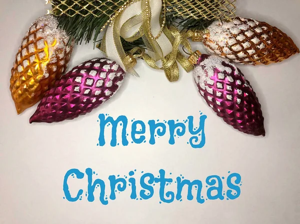 Різдвяні скляні конуси на білому тлі з синім знаком Веселого Різдва — стокове фото