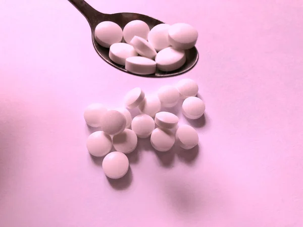 Pills on a pink background. Medical care and treatment — Stock Photo, Image