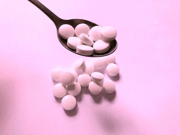 Comprimidos sobre um fundo rosa. Cuidados médicos e tratamento — Fotografia de Stock