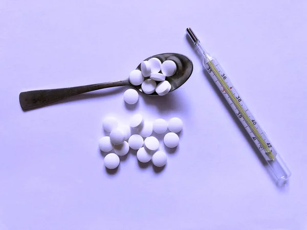 Comprimidos em um fundo roxo. Cuidados médicos e tratamento — Fotografia de Stock
