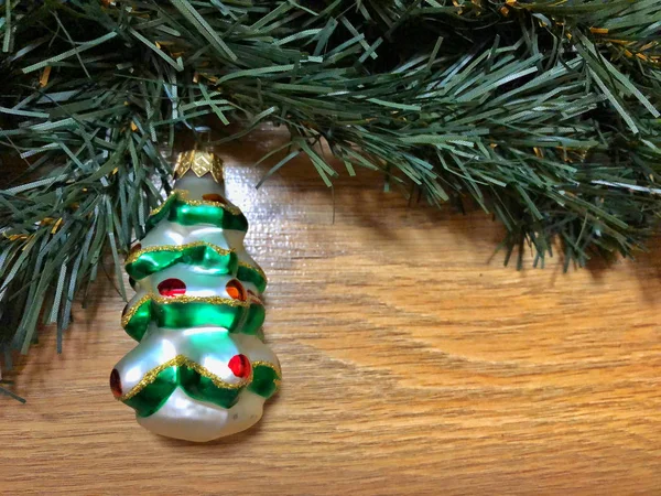 Fir branch with a toy on a wooden background — Stock Photo, Image