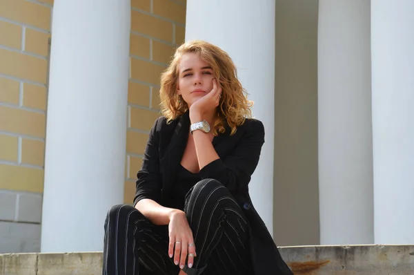 Bir iş siyah takım elbiseli seksi bir genç kadın oturuyor