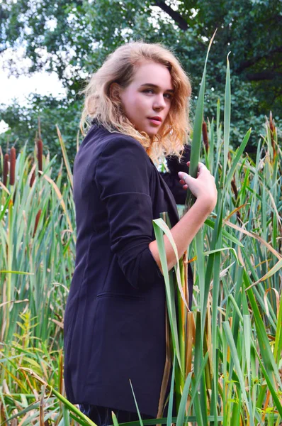 Сексуальна молода жінка в діловому чорному костюмі стоїть — стокове фото