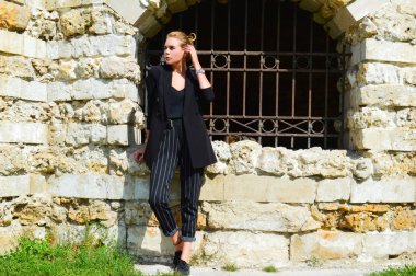 Bir iş siyah takım elbise seksi bir genç kadın duruyor