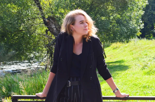 Bir iş siyah takım elbise seksi bir genç kadın duruyor