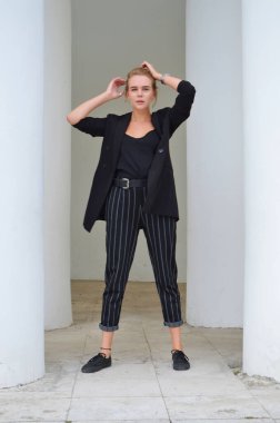 Bir iş siyah takım elbise seksi bir genç kadın duruyor