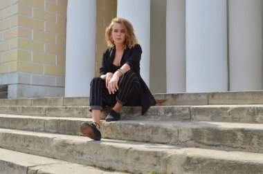 Bir iş siyah takım elbiseli seksi bir genç kadın oturuyor