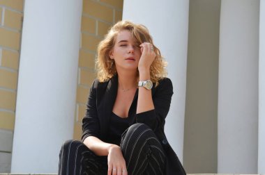 Bir iş siyah takım elbiseli seksi bir genç kadın oturuyor