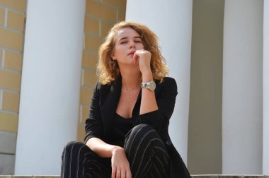 Bir iş siyah takım elbiseli seksi bir genç kadın oturuyor