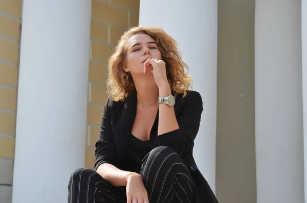 Bir iş siyah takım elbiseli seksi bir genç kadın oturuyor