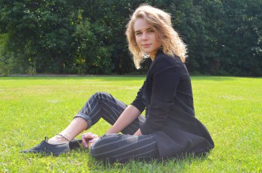 Bir iş siyah takım elbiseli seksi bir genç kadın oturuyor