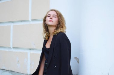 Bir iş siyah takım elbise seksi bir genç kadın duruyor