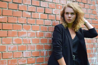 Bir iş siyah takım elbise seksi bir genç kadın duruyor