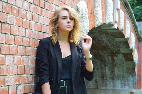 Una giovane donna sexy in un abito nero business è stand — Foto Stock