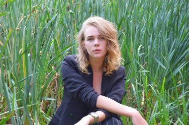 Bir iş siyah takım elbiseli seksi bir genç kadın oturuyor