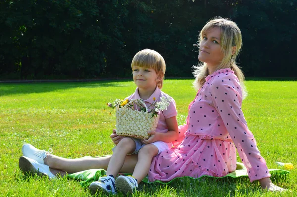 Niñito en la hierba con su madre en el parque de verano . — Foto de Stock