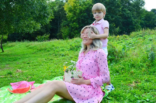Niñito en la hierba con su madre en el parque de verano . — Foto de Stock