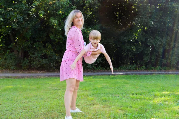 Niñito en la hierba con su madre en el parque de verano . — Foto de Stock