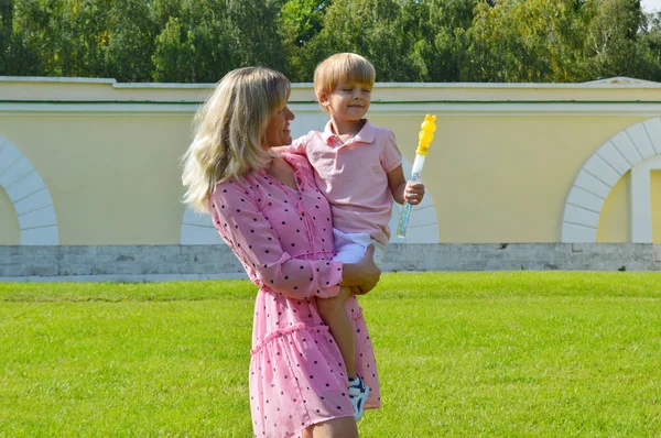 Little boy on the grass with her mother in the summer park. — Stock Photo, Image