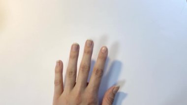 Tırnak makasıyla el manikürü. Beyaz arkaplanı kapatın. Evdeki kaplıca.