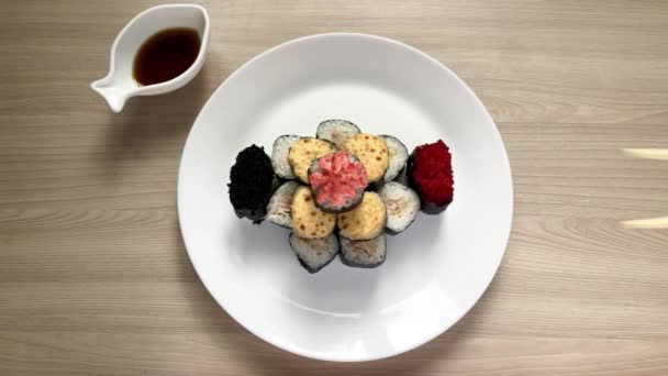 Sushi piegato sotto forma di torta su piatto bianco.Prende bastoncini di legno di sushi — Video Stock