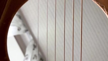 Kapatın. Parmaklarını gitarın tellerine vur. Gitarın içindeki video.