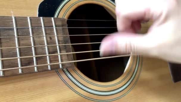 De cerca. Bust los dedos en las cuerdas de la guitarra — Vídeos de Stock