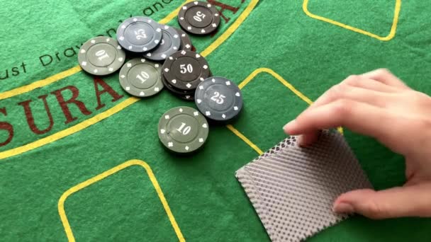 Mélanger les cartes à jouer sur un fond de table de poker. jetons de poker sur une table verte. — Video