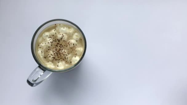 Cup of coffee with marshmallows and cinnamon. Pours white mini marshmallows — Stock Video