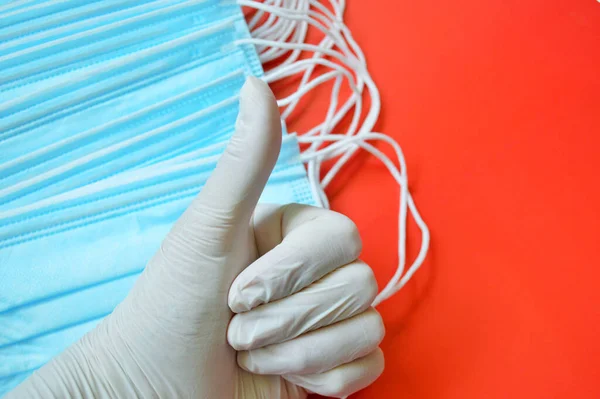Рука Белой Перчатке Показывает Большой Палец Фоне Синих Медицинских Масок — стоковое фото