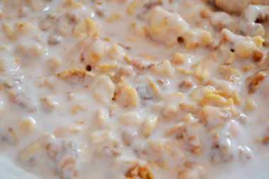 Kahverengi ahşap bir masada beyaz bir tabakta yoğurtlu müsli..