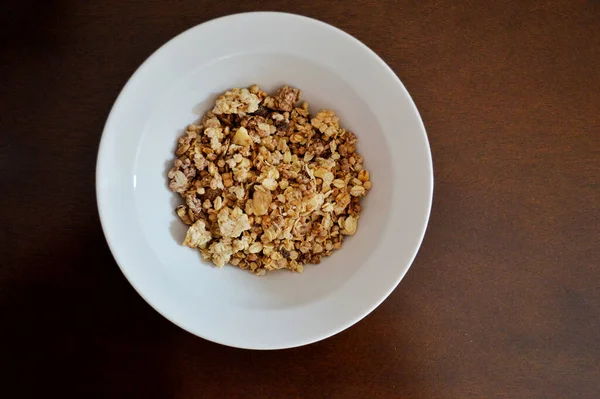 Trockenes Müsli Einem Weißen Teller Auf Einem Braunen Holztisch — Stockfoto