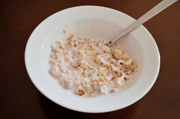 Muesli Joghurttal Fehér Tányéron Ezüst Kanállal Egy Barna Asztalon — Stock Fotó